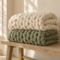 AI-generated concept of cream and sage chunky chenille blankets; finished items may differ